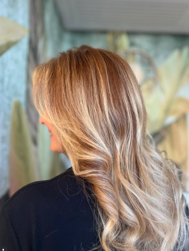 Capelli lunghi con schiariture calde realizzati in salone